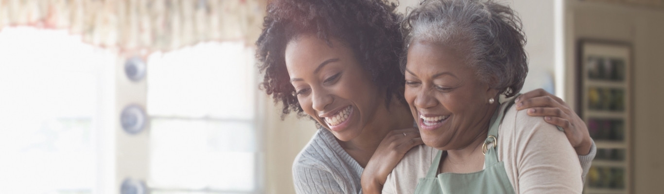 mother and daughter smiling in kitchen with turkey