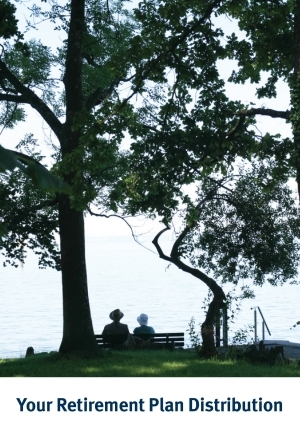 Senior couple sitting under a tree and looking out at the lake